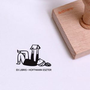Ex libris pecsét, hanyatt fekve olvasó lányt ábrázoló grafikával. Nyeles fa alapra készült, gumi lenyomattal, egyedileg megadott névvel készült.