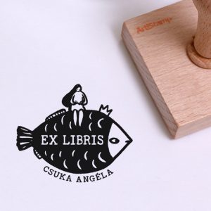 Ex libris pecsét, hal királyon ülő, olvasó lányt ábrázoló grafikával. Nyeles fa alapra készült, gumi lenyomattal, egyedileg megadott névvel készült.